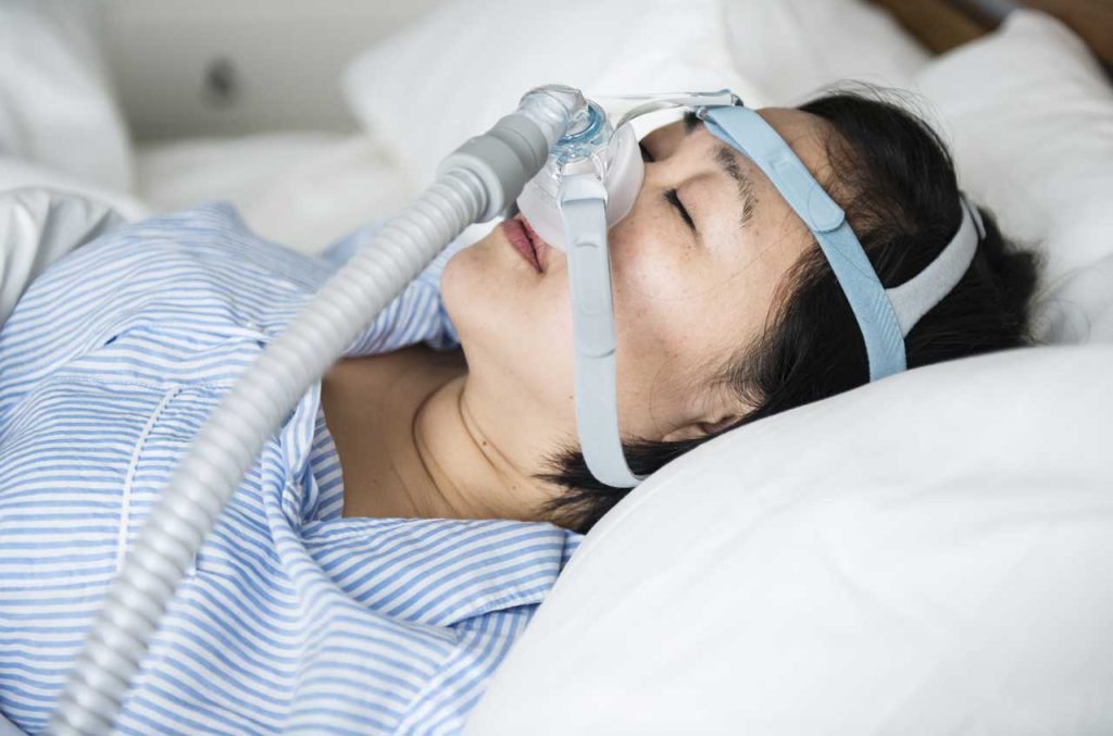 A sleeping woman wearing a CPAP mask